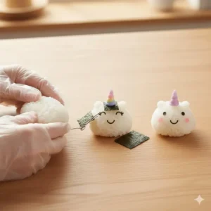 Close-up shot showing how to make the unicorn bento rice ball using edible markers and nori cutouts for the face and horn.